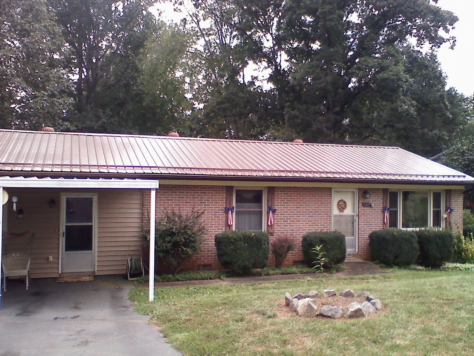 Bronze metal roof and carport on a brick ranch home — Roof Repair work by our crew in Poultney