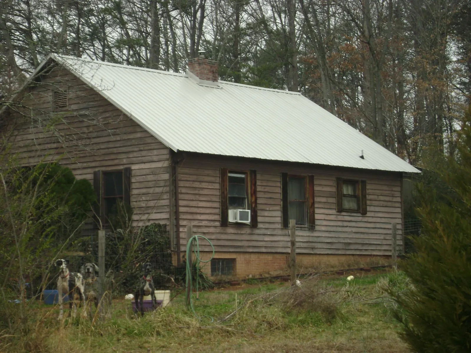 White metal roof on an old wood sided farmhouse, from a Metal Roof Installation job in Poultney